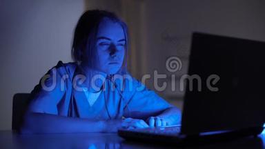 工作过度的女护士在黑暗的房间里坐在笔记本电脑前哭泣，压力很大